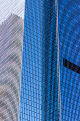 Obraz premium A close-up view of modern office buildings in downtown Los Angeles. The buildings feature sleek glass facades that reflect the surrounding structures, creating an intricate pattern of reflections.