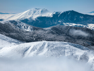 Obraz premium Towering snow covered volcano above a layer of cloud (Mount Asama)