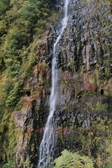 Majestic Waterfall Cascading Down Rocky Cliff Surrounded by Greenery