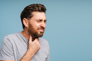 Fototapeta premium Portrait of sad, bearded, Latin man having sore throat, virus, flu. Treatment, health care concept