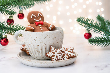 A gingerbread man is sitting in a cup of hot chocolate