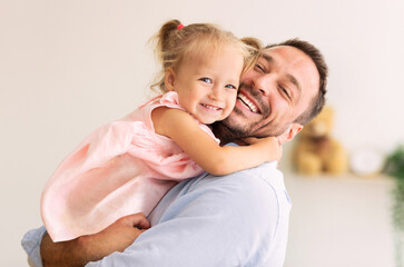 Happy Loving Family. Dad hugging his little daughter and looking at camera. Copy space, banner
