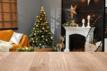 Empty table in room with Christmas tree and other festive decor
