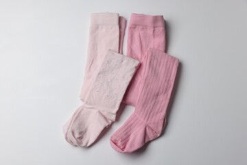 Beautiful pink child's tights on white background, top view