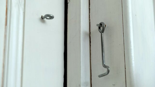 A person is currently opening a door with a hook in their hand