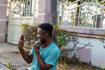 Fototapeta premium Young African American guy using mobile phone