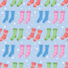 Seamless pattern with Christmas socks and snowflakes. Socks in different colors and ornaments. Red, blue, pink, green. Stockings for holiday projects, gift wrapping, textiles and seasonal design.