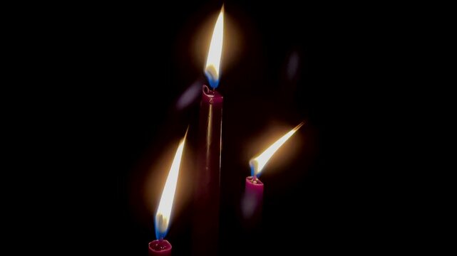 Red burning candles in the dark close up slow motion