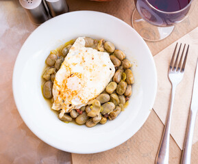 Image of a delicious dish of white beans with ham and fried egg