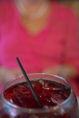 Glass of red wine with ice and straw in italian restaurant