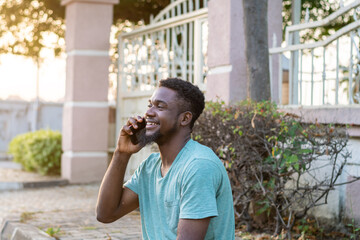 Young African American guy using mobile phone