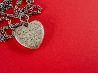 Fototapeta premium Engraved metal heart on a red background. Valentine's Day.