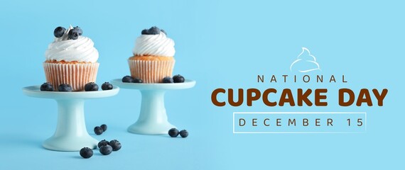 Tasty cupcakes with blueberries on light blue background. Banner for National Cupcake Day