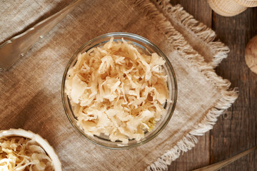 Homemade fermented cabbage or sauerkraut in a glass bowl on a table