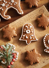 Decorating bell shaped homemade gingerbread Christmas cookie with white icing, top view