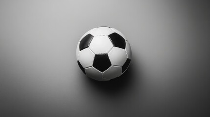 Obraz premium Black and White Soccer Ball on a Gray Background Perfect for Sports Themes and Athletic Events, Representing Fun and Team Spirit in Soccer Culture