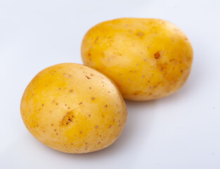 Closeup of raw yellow potatoes on white background. Healthy organic food.