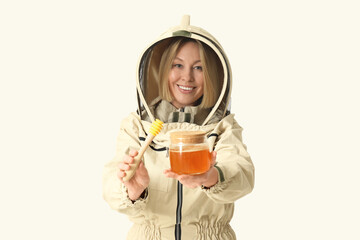 Female beekeeper with jar of sweet honey and dipper on white background