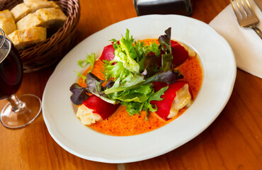 Tasty stuffed piquillo peppers with cod brandade in sauce with lettuce