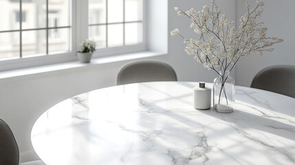 Minimalist white marble dining table with white flowers in a vase, sunlight reflecting off the surface.