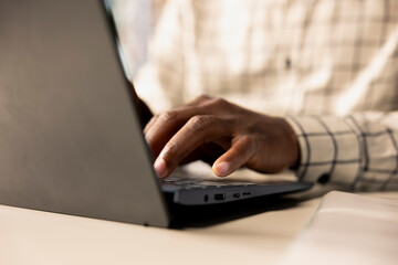 African american general manager reviews business forecasts and plans on his laptop at office desk, strategy planning. Data analyst focuses on company objectives and resource allocation. Close up.