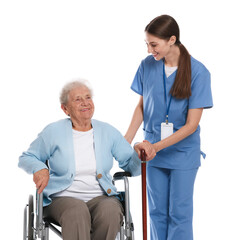 Obraz premium Caregiver assisting senior woman in wheelchair on white background. Home health care service