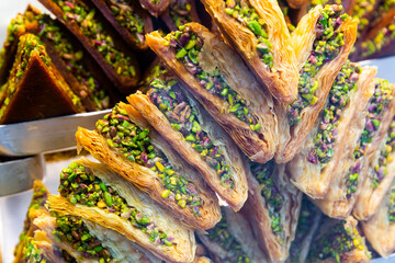 Oriental sweets pahlava with nuts, pistachio and honey on a tray