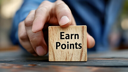 A Close-up View of a Hand Holding a Wooden Block with the Words 'Earn Points' Written on It, Motivational Message, Achievement, Progress, Rewards