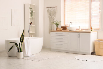 Bathtub, counter with sink and shelving unit in interior of bathroom