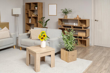 Interior of modern living room with grey sofas and sunflowers on wooden coffee table