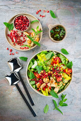 Arabic style salad with lettuce mix, vegetable and flatbread served as top view in a pomegranate mint vinaigrette on a design plate