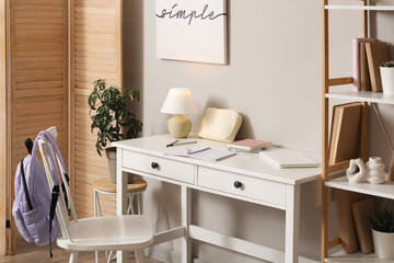 Student's workplace with notebooks and laptop in room