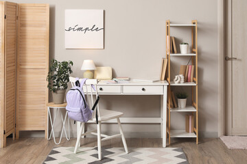 Interior of student's room with workplace, bookshelf and folding screen