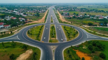 Naklejka premium Aerial view of a roundabout on a highway with traffic in the countryside.