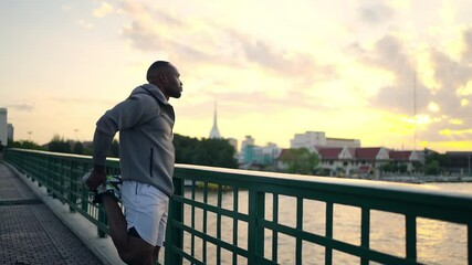 African man in sportswear stretching body before jogging exercise on city street. Healthy guy enjoy outdoor active lifestyle sport training running workout in the city. Health care motivation concept.