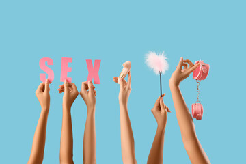 Women with word SEX and toys on blue background