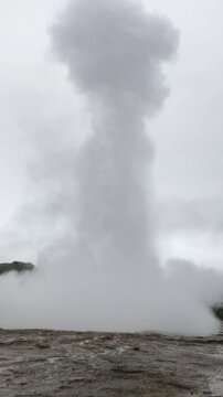 geyser erupting on cloudy day
