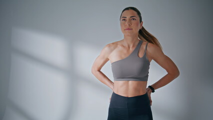 Obraz premium Sportswoman squatting resistance band around legs at studio. Girl training body