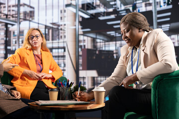 Team of empowered businesswomen in a corporate meeting making a deal, signing a contract that signifies business growth. Female leaders working on legal forms of insurance in the office.