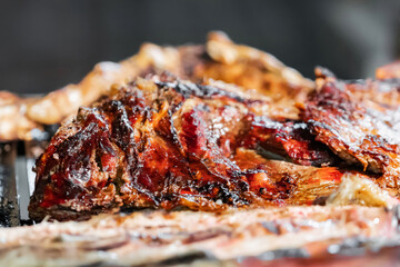 Close-up of juicy grilled meat on barbecue, rich, caramelized texture with charred edges