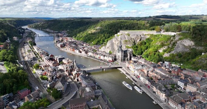 river Meuse flowing through Dinant city surrounded by green hills in the Belgian province of Namur