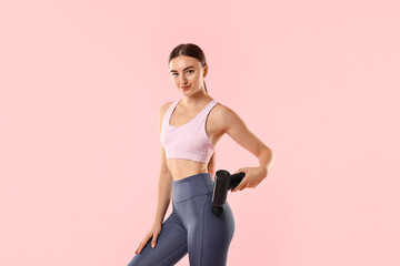 Woman using percussive massager to relax hip muscles on pink background