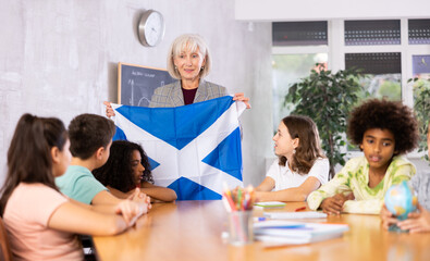 in geography lesson, elderly teacher very eloquently tells children about history of ancient scotland