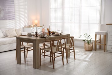 Stylish table setting with dishware, cutlery and burning candles indoors