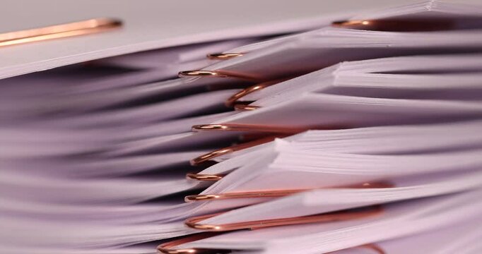 blank sheets of paper connected by copper staples, a close-up of a piece of new cellulose paper divided by paper clips into parts