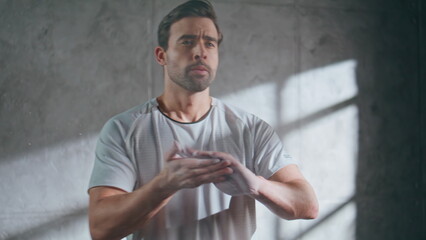 Male athlete rubbing hands with magnesium. Closeup sportsman using talc powder