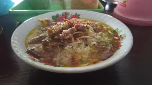 A warm bowl of soto ayam being enjoyed, showcasing rich broth, shredded chicken, fresh herbs, and comforting Indonesian flavors.