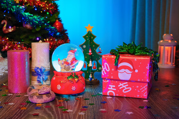 Snake - Symbol of the Year 2025 in the Chinese Lunar Calendar. Festive Christmas Gift Box, Christmas Tree, Glass Snow Globe with Santa Claus, Red Candles, and a Calendar Marked with the 25 year number