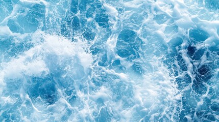 beautiful photo of blue water flowing in waves with white foam in a ocean. taken from up top above perspective. wallpaper background