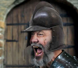 A man in medieval armor shouts in front of a castle gate
